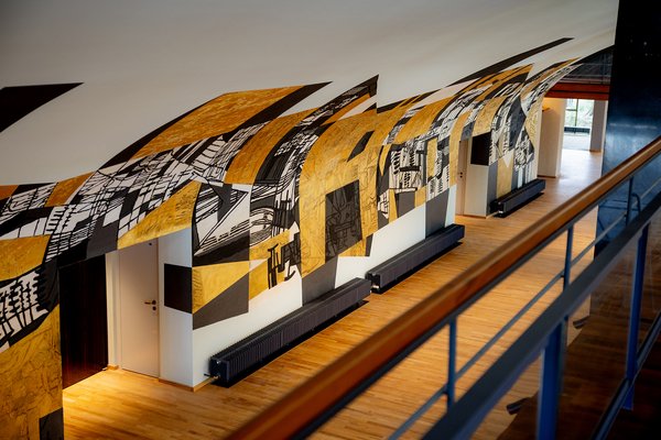 Blick über Geländer auf künstlerisch gestaltete Wand mit gold-schwarzem Muster in der Beethovenhalle